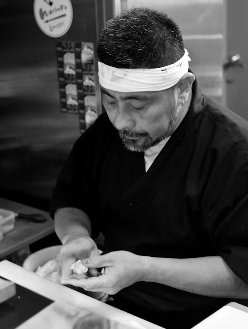 Đầu bếp Kazu ấn nhẹ tôm lên cơm sushi